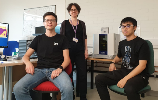 Photo of Dr. Fumagalli and her team in a scientific lab. Asylum Research's Cypher ES AFM appears in the background.